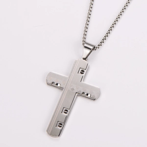 Close-up of silver cross pendant with wavy pattern and box chain necklace
