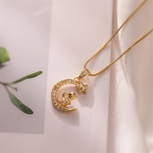 Nahaufnahme von goldenem Mond- und Hasenanhänger mit Zirkonia auf Seide