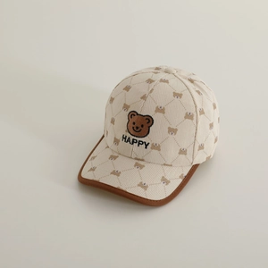 Close-up of beige corduroy kids baseball cap featuring embroidered bear patch and happy text