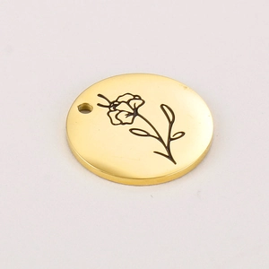 Close-up of gold-plated stainless steel round pendant with engraved floral pattern