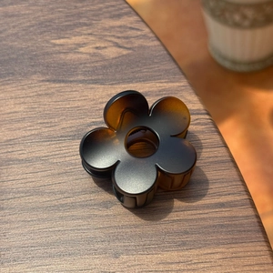 Vue détaillée d'une pince à cheveux fleur de 5cm avec dégradé marron sur bois