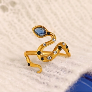 Macro shot of snake ring with blue droplet stone and crystals on knit surface