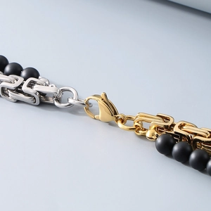 Detailed close-up of king chain with black onyx beads and golden lobster clasp