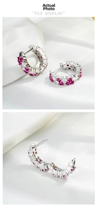 Detailed view of silver hoop earrings with micro-paved red and white zircon stones