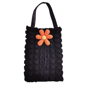 Detail of black popcorn fabric tote bag featuring a vibrant orange 3D sun flower decor