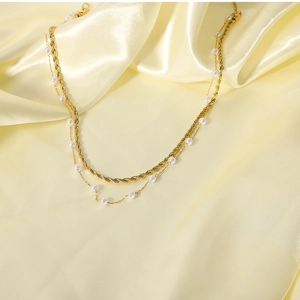 Double-layered 18K gold stainless steel chain necklace with small pearls on yellow silk fabric