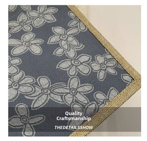 Detailed view of grey floral fabric with jute woven edges and high-quality stitching