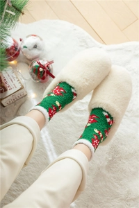 Détail de chaussettes de Noël en molleton corail vert et pantoufles en peluche blanche