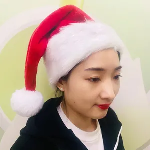 Classic red plush Christmas hat with thick white faux fur trim worn by a model