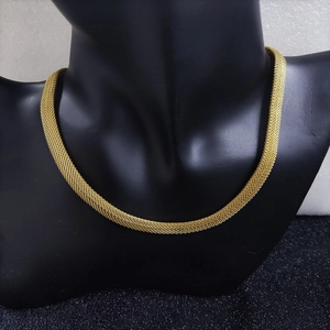 Detail of 18k gold plated mesh chain necklace showing woven texture and metallic luster