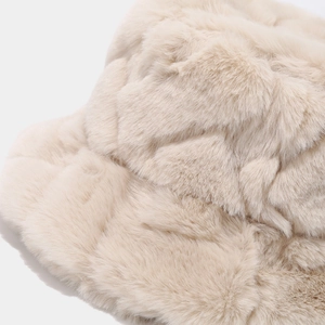 Détail du chapeau bob en fausse fourrure beige avec motif losange et texture douce