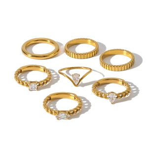 7-piece 18k gold plated stainless steel ring set with zircon accents on white background