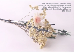 Flat lay of pink sola flower with black diffuser sticks and dried eucalyptus leaves