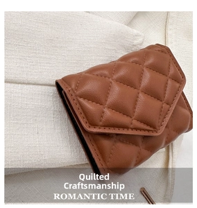 Close-up of quilted diamond pattern on dark brown leather wallet with snap closure