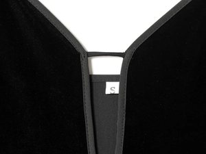 Détail macro de l'encolure en V et étiquette de taille S sur robe en velours
