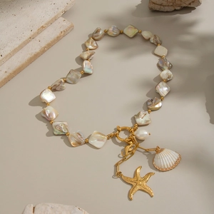 Detail of beaded shell necklace featuring gold seahorse, starfish and conch pendants