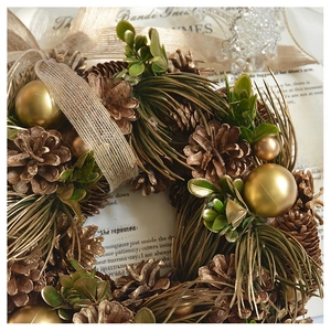 Close-up of golden pinecones and matte ornaments on a vintage Christmas wreath detail