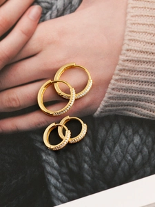 Detail of two pairs of gold S925 sterling silver hoop earrings with pavé zircon stones