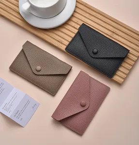 Three leather envelope card holders in black, tan and rose pink with litchi texture