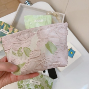 Macro shot of pink rose floral jacquard fabric on a mini canvas zipper coin pouch