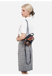 Detailed side view of patchwork mini backpack with adjustable straps on female model