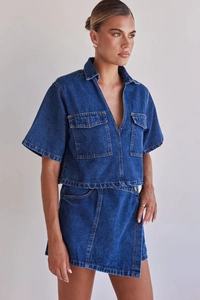 Close-up of asymmetric denim skirt and utility style shirt set with stitching details