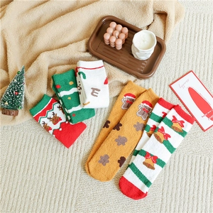 Close-up of festive Christmas coral fleece socks with reindeer and tree patterns