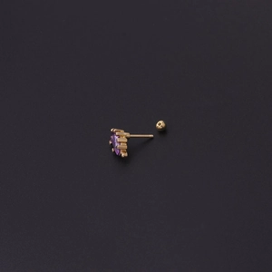 Makroaufnahme von 20G Gold-Dinosaurier-Ohrknorpelstecker mit lila Zirkon und Schraubverschluss