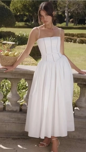 Detailed close-up of white midi dress with corset bodice and delicate lace trim accents