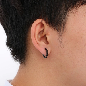 Detailed close-up of a black Mobius twist hoop earring worn on a male ear model