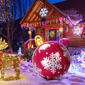 Outdoor inflatable Christmas ball with white snowflakes on red PVC placed in snow