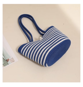 Detailed shot of striped woven shoulder bag with pearl clasp and cotton knit texture