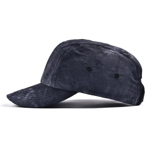Détail d'une casquette 5-panel gris tie-dye montrant les œillets et l'effet marbré