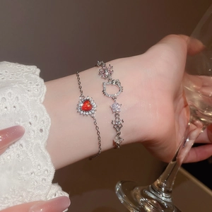 Detail of zircon heart and cartoon cat pendants on elegant silver charm bracelets