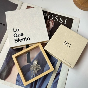 Detalle del collar de perlas en estuche amarillo con cajas de regalo de la marca