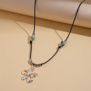 Détail du pendentif fleur argentée sur cordon noir avec perles en céramique verte