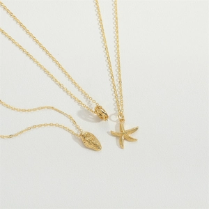Gold starfish seashell pendant necklace set displayed on textured white background