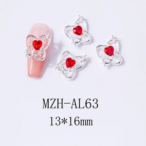 Detailed view of silver heart nail charms with red rhinestones and star accents