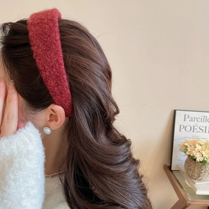 Close-up of a vintage red plush headband worn by a model in a cozy winter setting