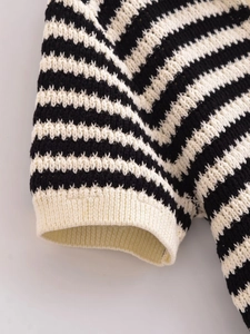 Dettaglio del polsino a righe del maglione in maglia con trama a coste e cuciture fini