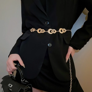 Detail of gold geometric interlocking rings waist chain with rhinestones on a blazer