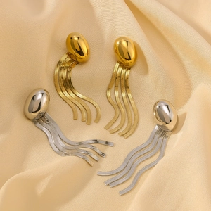 Jellyfish-style fringe chain earrings in gold and silver finish on silk background