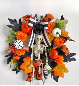Detail of Halloween wreath with maple leaves, pumpkin decor, skeleton and festive ribbons