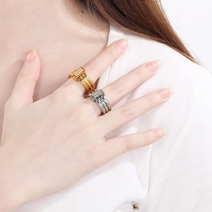 Detail of 18k gold and silver interlocking rings with pavé diamonds on finger