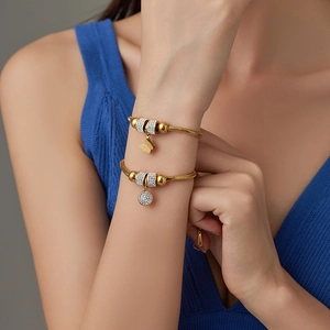 Detail of 18K gold titanium snake chain bracelet with butterfly and zircon star charms