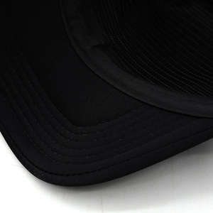 Detailed macro view of black baseball cap with multi-row stitched brim and mesh lining