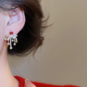 Detailed close-up of gold-plated zircon firework earrings featuring red and green gems