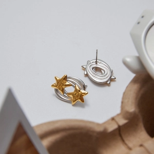 Detail view showing the front and back design of star-shaped stainless steel earrings