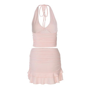 Detailed flat lay of pink two-piece set featuring halter neck top and ruffled mini skirt