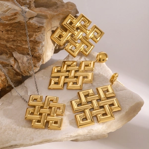 Set collana e orecchini a nodo celtico dorato su sfondo di pietra minerale bianca
